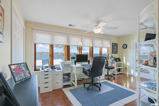 home office with dark parquet flooring and ceiling fan