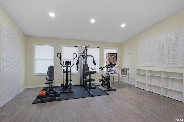 workout area with hardwood / wood-style flooring and vaulted ceiling