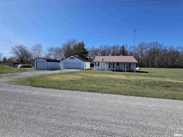 ranch-style home with covered porch, a garage, an outdoor structure, and a front yard