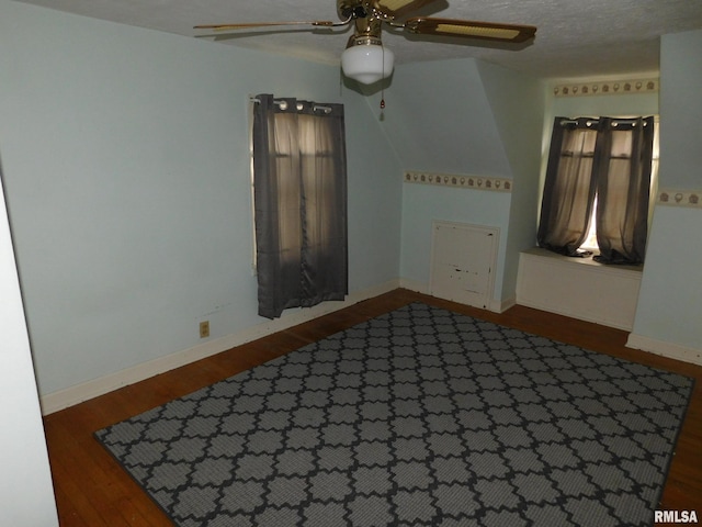 unfurnished room with a textured ceiling, ceiling fan, and dark wood-type flooring