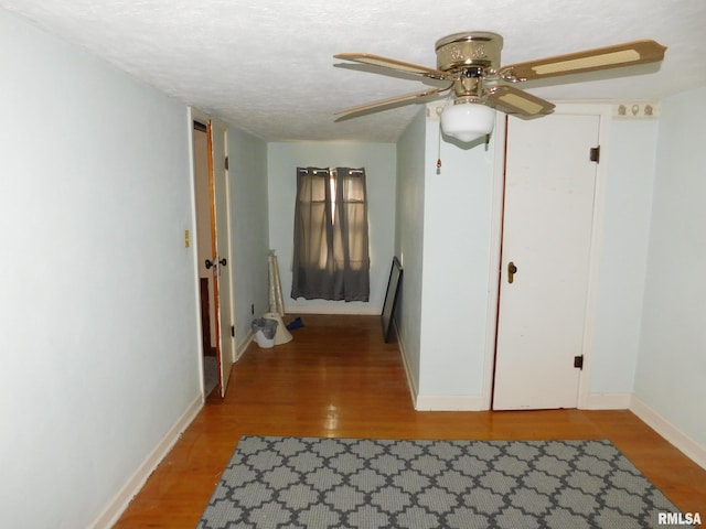 hallway with a textured ceiling and hardwood / wood-style flooring