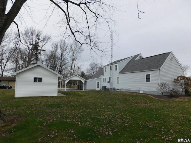 exterior space with central AC unit, a carport, and a lawn