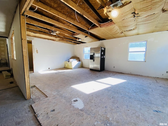 basement with stainless steel fridge with ice dispenser