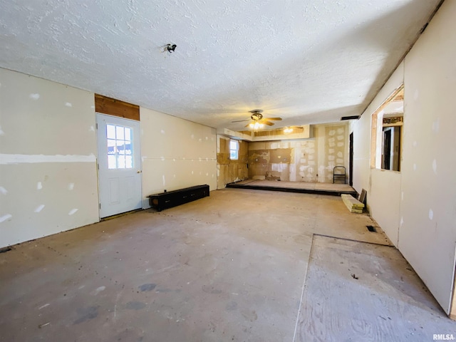 empty room with ceiling fan and a textured ceiling