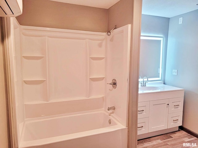 bathroom with hardwood / wood-style floors, vanity, a wall unit AC, and tub / shower combination