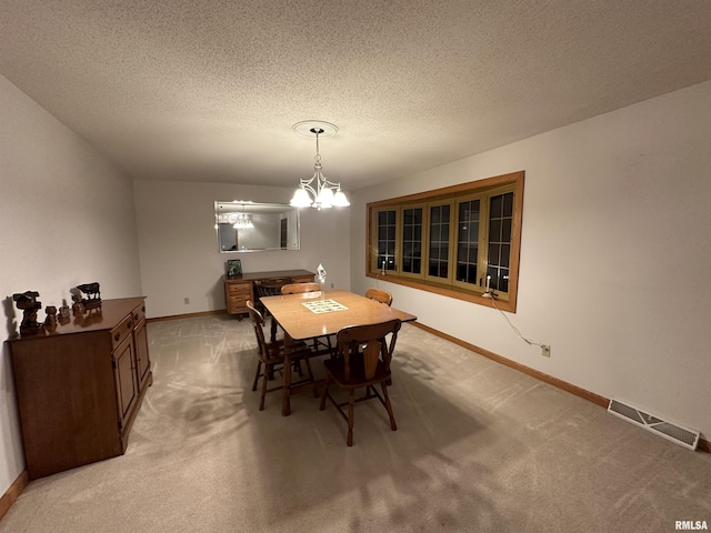 carpeted dining room featuring a textured ceiling and an inviting chandelier