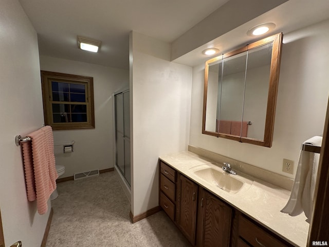 bathroom with vanity, an enclosed shower, and toilet