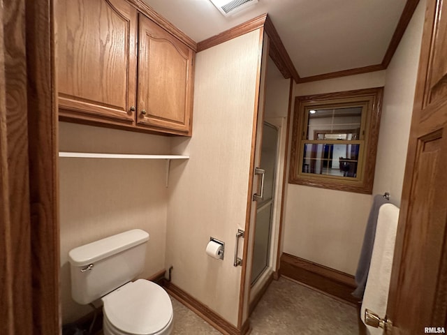 bathroom featuring toilet, a shower with door, and crown molding