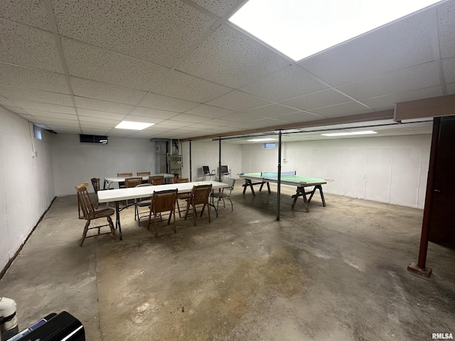 playroom featuring a paneled ceiling and concrete floors