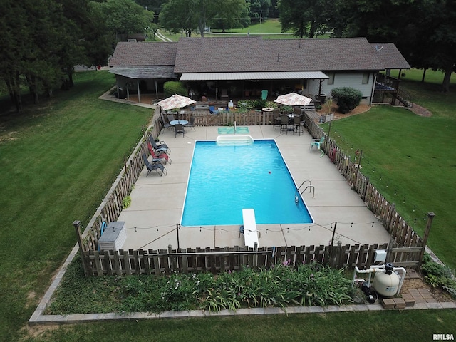 view of swimming pool featuring a yard, a diving board, and a patio area