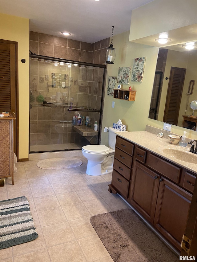 bathroom featuring tile patterned floors, vanity, an enclosed shower, and toilet