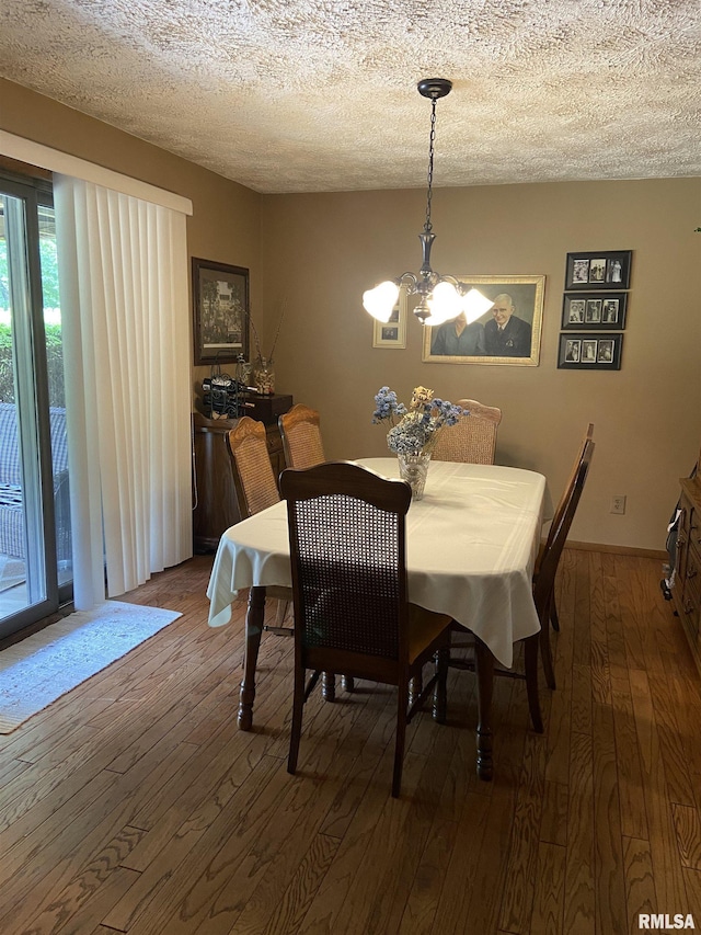 dining area featuring a chandelier, a textured ceiling, and dark hardwood / wood-style flooring