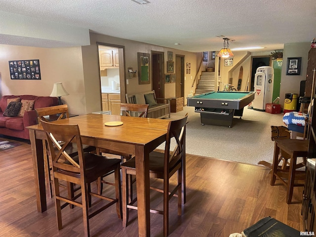 dining space featuring hardwood / wood-style floors, a textured ceiling, and pool table