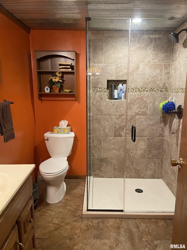 bathroom with vanity, toilet, and a shower with shower door