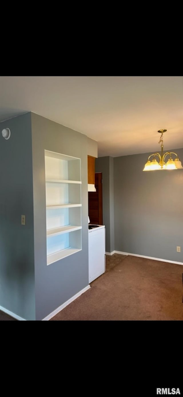 1408 Manning St, Murphysboro, IL 62966 - empty room featuring dark carpet, built in shelves, baseboards, and an inviting chandelier