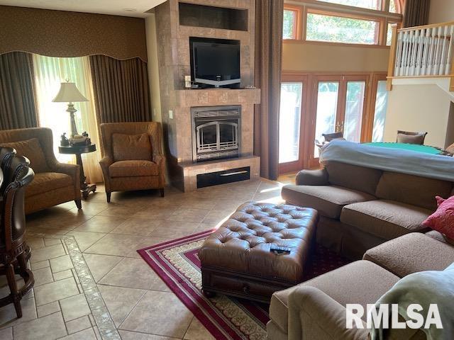 living room with light tile patterned flooring and a tiled fireplace