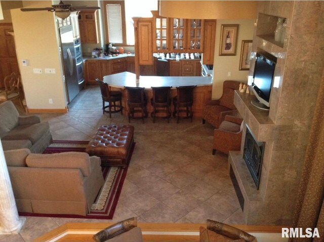 living room with ceiling fan and a premium fireplace