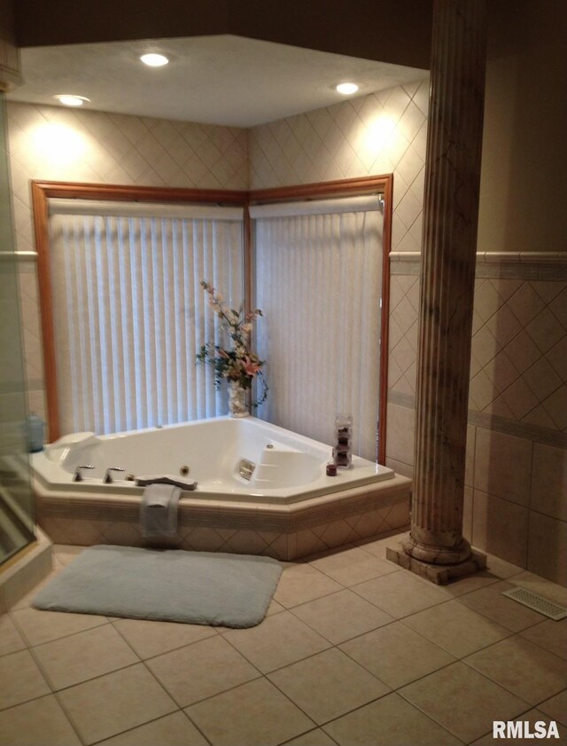 bathroom with tile patterned flooring and a relaxing tiled tub