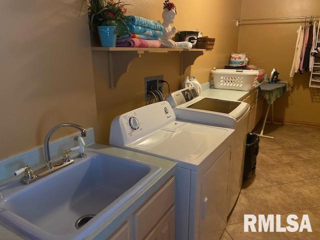 laundry area with washer and dryer, light tile patterned flooring, and sink