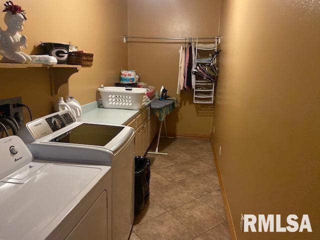 clothes washing area featuring light tile patterned flooring, cabinets, and independent washer and dryer