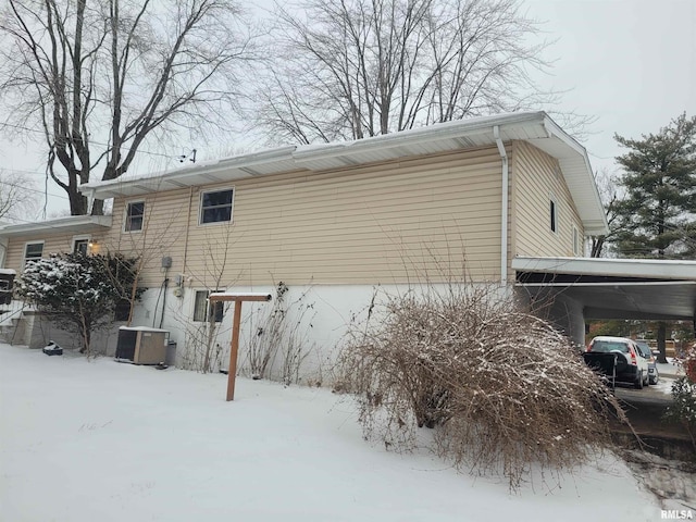 snow covered property featuring central air condition unit