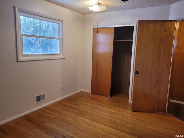 unfurnished bedroom featuring a closet and light wood-type flooring