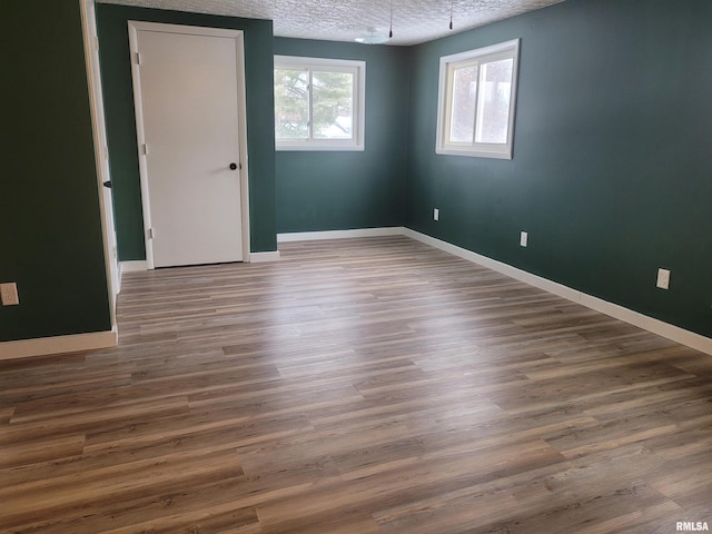 spare room with a textured ceiling and dark wood-type flooring