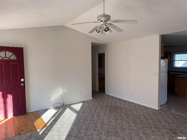 unfurnished living room featuring carpet flooring, ceiling fan, and lofted ceiling