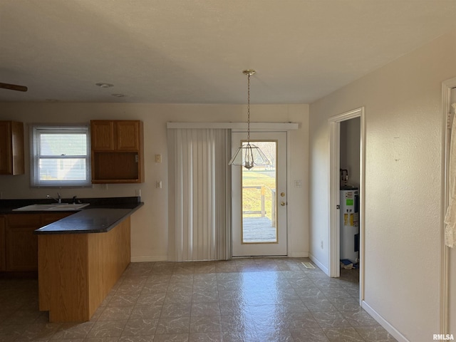 kitchen featuring water heater, sink, and hanging light fixtures