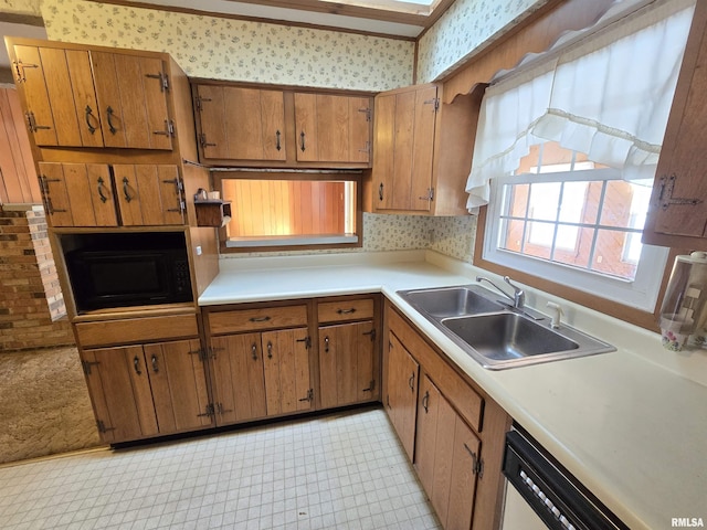 kitchen featuring black microwave, sink, and white dishwasher