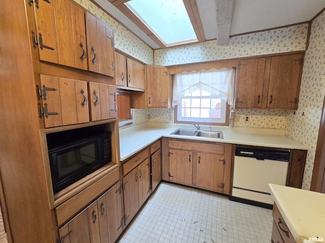 kitchen featuring a skylight, black microwave, sink, beam ceiling, and dishwasher