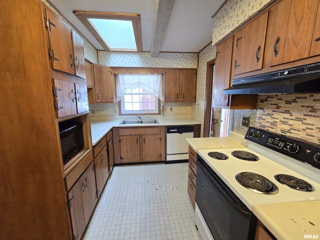 kitchen with beamed ceiling, white appliances, a skylight, and sink