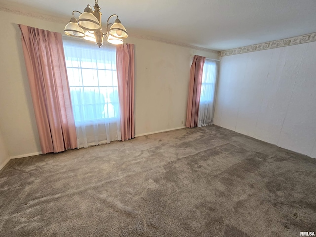 carpeted empty room with a healthy amount of sunlight and a notable chandelier