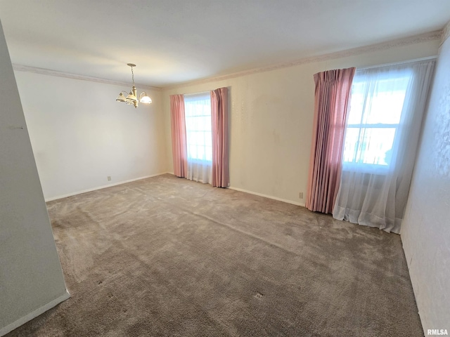 empty room featuring carpet flooring, crown molding, and a chandelier