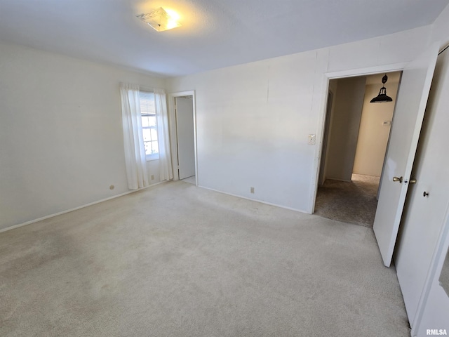 unfurnished room featuring light carpet