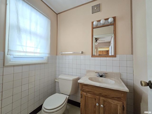 bathroom with plenty of natural light, vanity, tile walls, and toilet