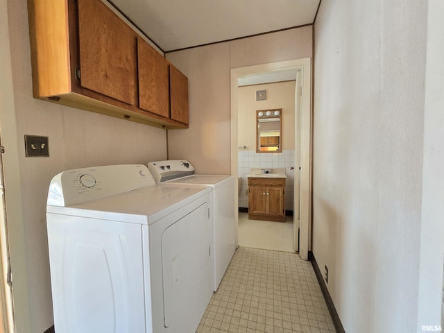 laundry room with cabinets, separate washer and dryer, and sink