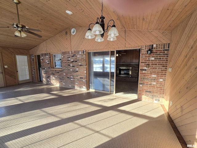 unfurnished dining area with wooden walls, high vaulted ceiling, wood ceiling, and ceiling fan with notable chandelier