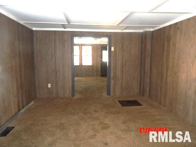 carpeted empty room with wooden walls