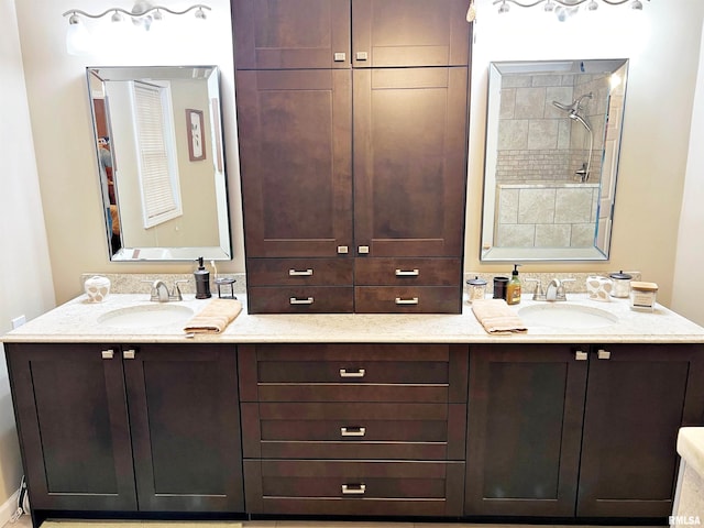 bathroom with tiled shower and vanity