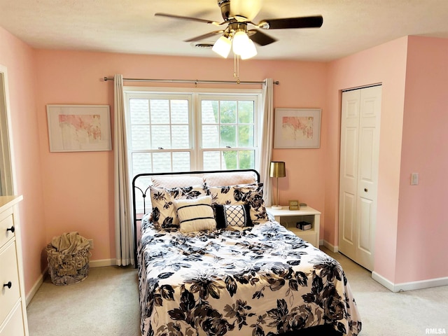 bedroom featuring ceiling fan, a closet, and light carpet