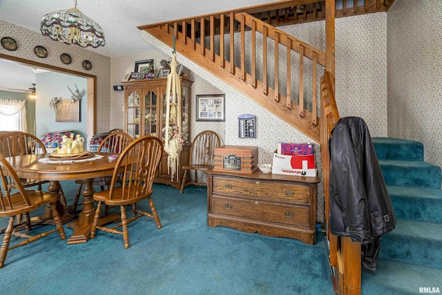 dining room with dark colored carpet and a textured ceiling