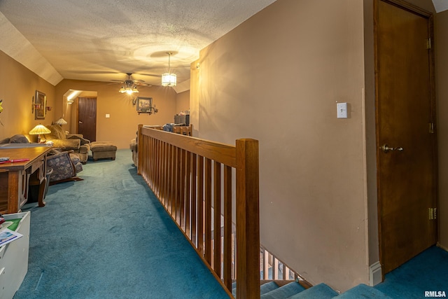 hallway featuring a textured ceiling, carpet, and lofted ceiling