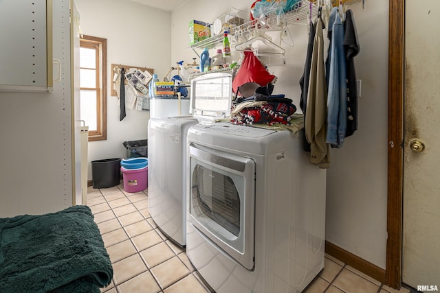 laundry area featuring a healthy amount of sunlight, independent washer and dryer, and light tile patterned floors