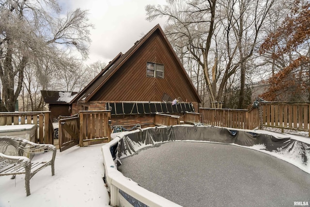 view of snow covered back of property