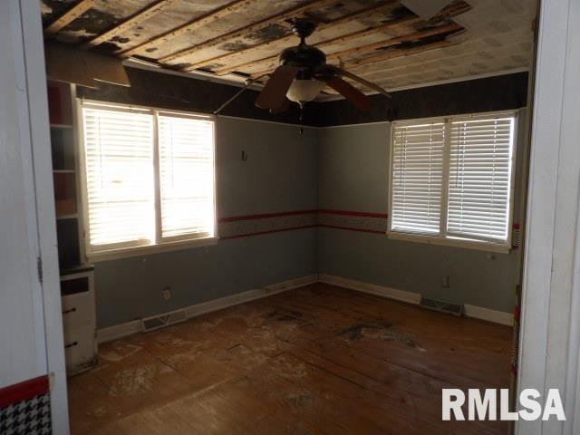 spare room with visible vents, baseboards, and a ceiling fan