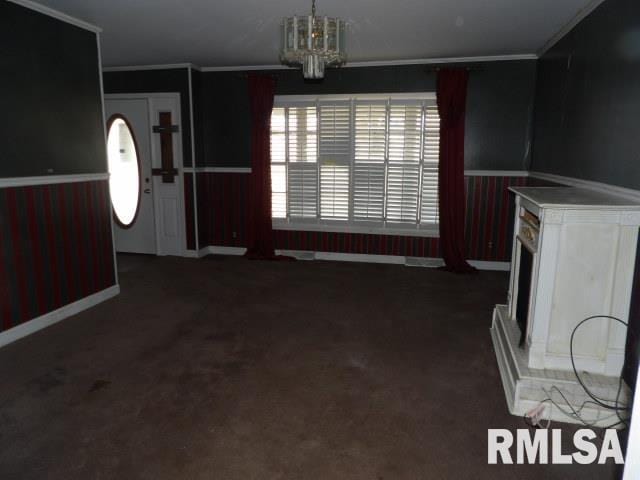 interior space featuring crown molding, carpet flooring, and a notable chandelier