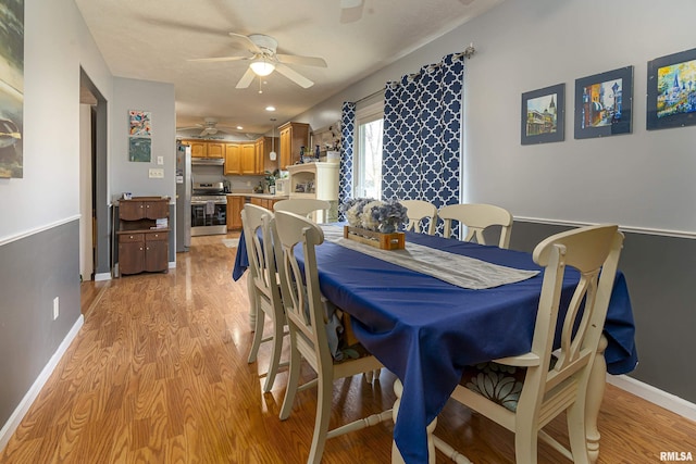 dining space with ceiling fan and light hardwood / wood-style flooring