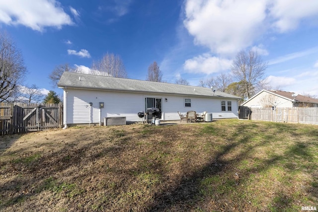 back of house featuring a lawn, a patio area, and central AC