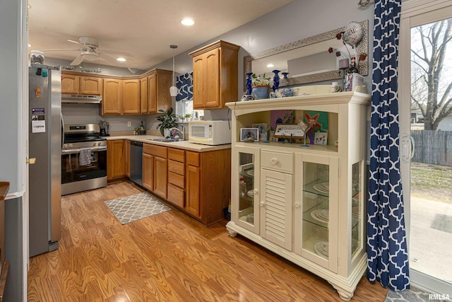 kitchen featuring pendant lighting, sink, ceiling fan, light wood-type flooring, and stainless steel appliances